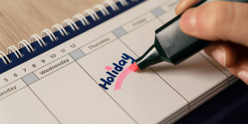 A calendar with the word holiday written and being highlighted