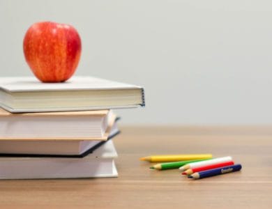Desk with books, building blocks and an apple