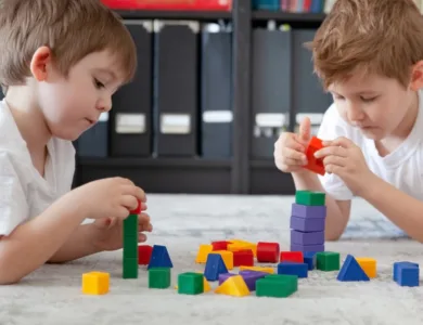 Two children at school playing with coloured blocks