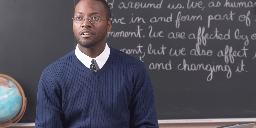 Teacher sat in front of blackboard