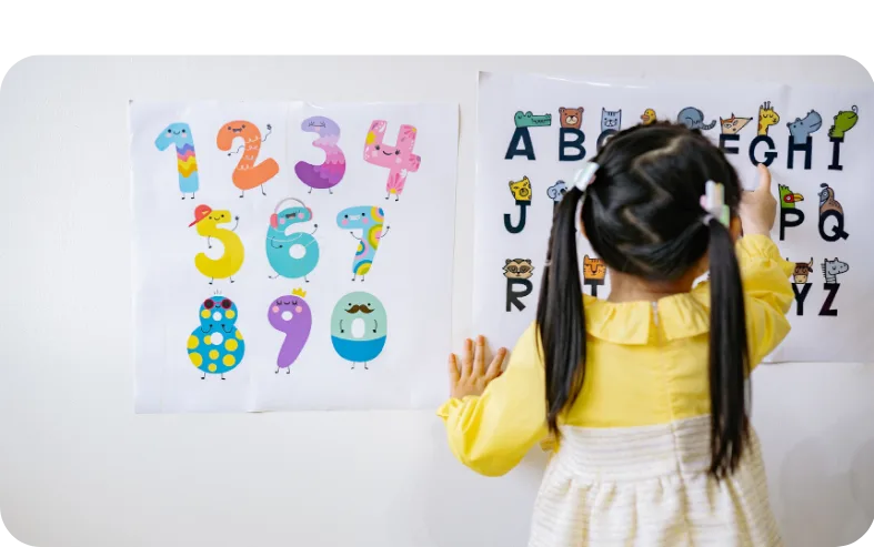 A child at nursery looking at numbers on a white board